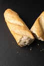 Broken in half baguette on a stone background