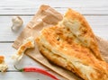 broken half pita bread caucasian, lying on a cutting board. Light wood background. Royalty Free Stock Photo