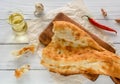 broken half pita bread caucasian, lying on a cutting board. Light wood background. Royalty Free Stock Photo