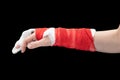 Broken hand with white gypsum and red bandage, thumb and index finger out, isolated on black background Royalty Free Stock Photo