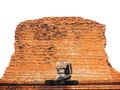 A broken, headless Buddha statue in front of an old brick wall with a white backdrop