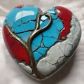 broken heart with a blue and red stones on a gray background Royalty Free Stock Photo