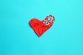 Broken heart breakup concept separation and divorce icon. Red crumpled paper shaped as a torn love on blue background.