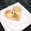 Broken Heart icon. Bronze Broken Heart symbol on white marble podium