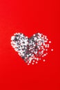 Broken heart made of silver confetti on red. Royalty Free Stock Photo