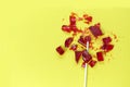 Broken heart red lollipop sweet isolated on yellow background