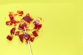 Broken heart red lollipop sweet isolated on yellow background