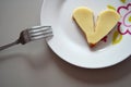 Broken heart shape slice of bread with cheese on a plate Royalty Free Stock Photo