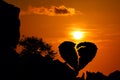 Broken heart-shaped stone on a mountain with red sky sunset background Royalty Free Stock Photo