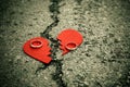 Broken heart with wedding rings on cracked asphalt - divorce concept - Royalty Free Stock Photo