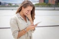 Broken hearted woman reading bad news on smartphone Royalty Free Stock Photo