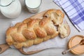 Broken homemade braided bread, milk and honey on white wooden table, flat lay. Traditional Shabbat challah Royalty Free Stock Photo