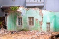 Broken house after earthquake. Old building deconstruction with new modern building on background