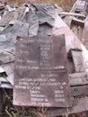 Broken information signs with inscriptions lying in the garbage thrown into the landfill