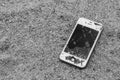 Broken iPhone 4S on sand ground