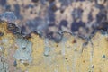 Broken iron surface with old yellow flaky paint on the background of another old iron