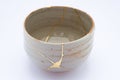 Broken Japanese handmade bowl restored with the antique japanese kintsugi real gold technique Royalty Free Stock Photo
