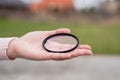 Broken lens filter in hand. Cracked photo-filter Royalty Free Stock Photo