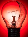 Broken Lightbulb Glowing with Red Light Royalty Free Stock Photo