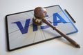Broken tablet computer screen with logo of VISA and judge's gavel. Editorial conceptual 3d rendering