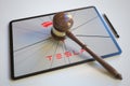 Judge's gavel and broken tablet computer screen with logo of TESLA. Editorial conceptual 3d rendering