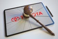 Judge's gavel and broken tablet computer screen with logo of TOYOTA. Editorial conceptual 3d rendering