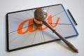 Judge's gavel and broken tablet computer screen with logo of AU. Editorial conceptual 3d rendering