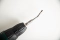 Broken low-quality drill in a screwdriver on a white background, industry
