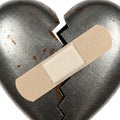 A broken metal heart with a plaster. Royalty Free Stock Photo