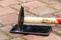 Broken mobile phone hit by hammer lying on pavement Royalty Free Stock Photo