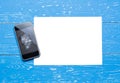 Broken mobile phone with paper sheet on vintage painted table Royalty Free Stock Photo