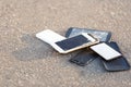 The broken mobile phones are on asphalt. Royalty Free Stock Photo