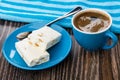 Broken nougat, spoon in saucer, blue napkin, coffee in cup Royalty Free Stock Photo