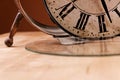 Broken old analog clock with glass and metal frame on wooden table, broken structure Royalty Free Stock Photo