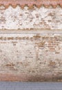 Broken old bricklaying wall from red white bricks with damaged plaster and road pavement background texture Royalty Free Stock Photo