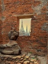 Broken old buddha statue near brick wall window view of three ancient pagoda Royalty Free Stock Photo