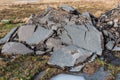 Broken old cracked asphalt after the road upgrade stacked in the heap on the ground to be recycled