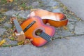 Broken old guitar lying on the concrete, discarded on a New York City street