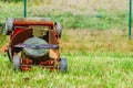 Broken old lawnmower in backyard grass Royalty Free Stock Photo