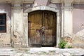 Broken old wooden entrance doors locked with padlock mounted on abandoned suburban family house wall Royalty Free Stock Photo