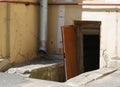 Broken open brown door to the basement of an apartment building