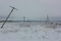 Broken phase electrical power lines with hoarfrost on the wooden electric poles on countryside in the winter after storm Royalty Free Stock Photo