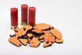 Broken pieces of flying clay pigeon target and shotgun shell bullets on white background , Gun shooting game