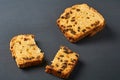 Broken pieces of tasty sweet homemade bread with raisin lies on dark concrete table in kitchen Royalty Free Stock Photo