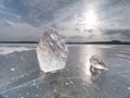 Broken pieces of thick ice over frozen lake shine in sun. Royalty Free Stock Photo