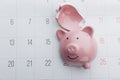 Broken piggy bank on a white calendar background, saving and investment concept. Top view Royalty Free Stock Photo