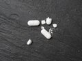 Broken Pills, Crushed Aspirin, Split Tablet, Broken Pill Capsules, Crumbling White Drugs on Black