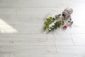 Broken pink ceramic vase and bouquet on wooden floor. Space for text