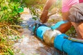 Broken pipe in hole with water motion at roadside and plumber working repair and Locking Pliers Royalty Free Stock Photo