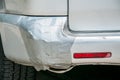 Broken plastic rear end bumper on the silver van glued with duct tape